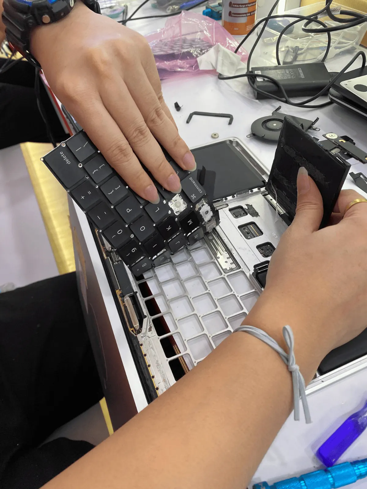 Technician handling the replacement battery before fitting
