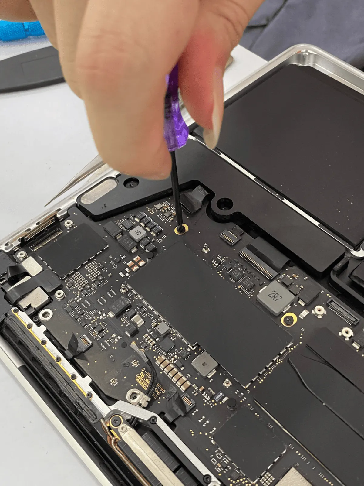 MacBook logic board exposed during component-level repair
