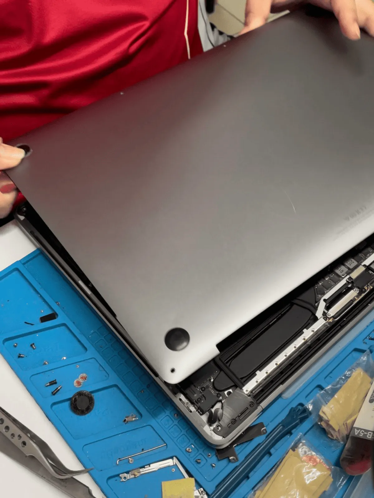 MacBook opened on the bench to test the display cable before quoting a panel